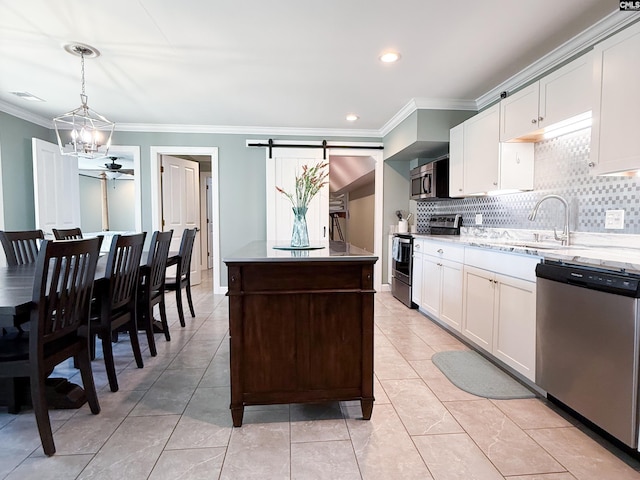 kitchen featuring decorative backsplash, a barn door, appliances with stainless steel finishes, and a center island