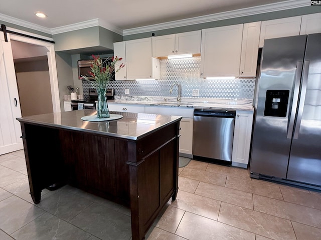 kitchen featuring ornamental molding, a sink, backsplash, white cabinetry, and appliances with stainless steel finishes