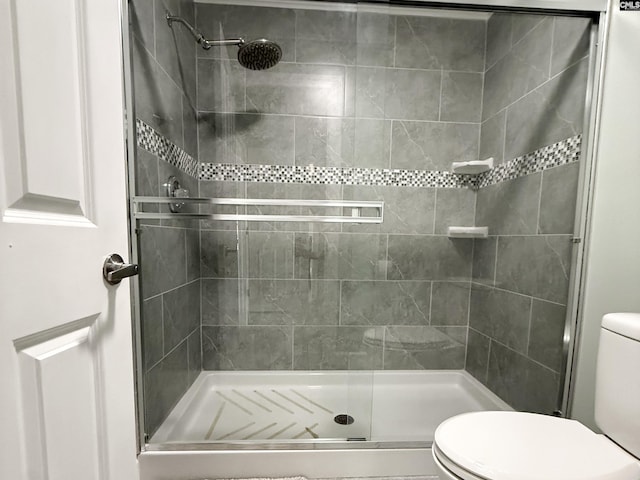 full bath with toilet and a stall shower