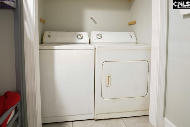 clothes washing area featuring light tile patterned floors, separate washer and dryer, and laundry area