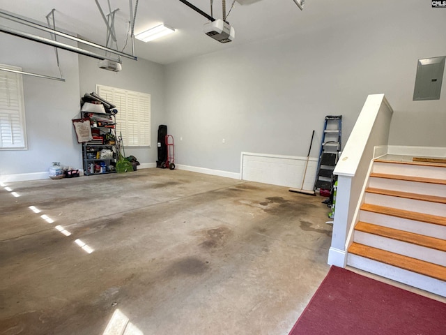 garage with electric panel, a garage door opener, and baseboards