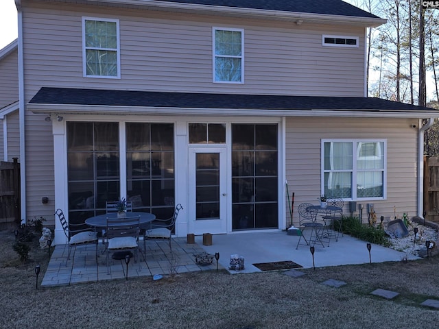 back of house featuring a patio and a shingled roof