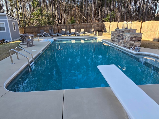 view of swimming pool with a patio area, a fenced in pool, a diving board, and a fenced backyard