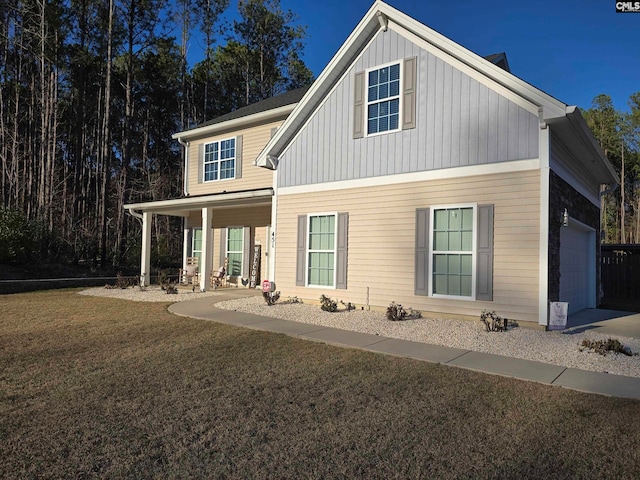 view of front of property with a garage, board and batten siding, a porch, and a front yard