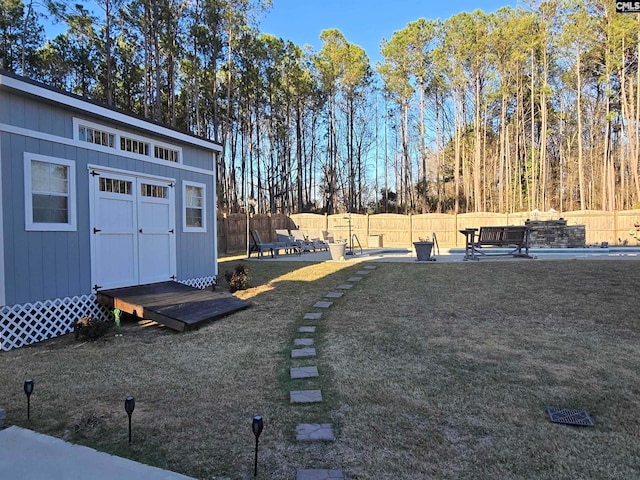 view of yard with an outdoor structure, a fenced backyard, and a patio area