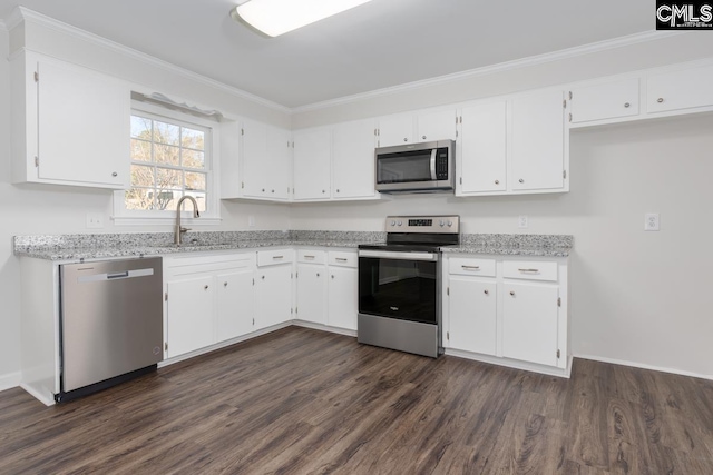 kitchen featuring light stone counters, appliances with stainless steel finishes, white cabinets, and dark wood finished floors