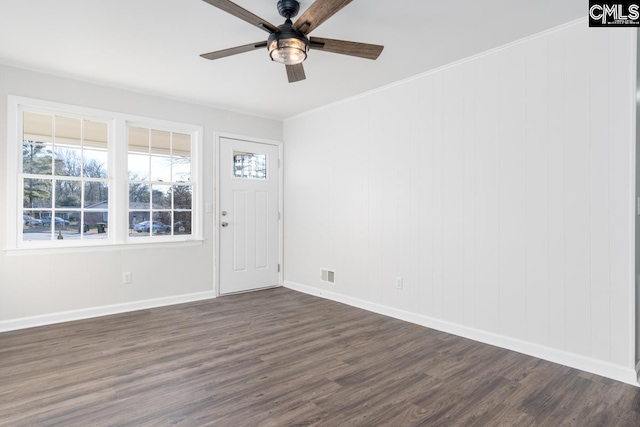 interior space with visible vents, baseboards, ceiling fan, ornamental molding, and dark wood-style flooring