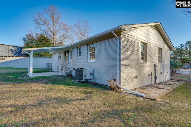 view of property exterior featuring central AC unit, fence, a yard, crawl space, and brick siding