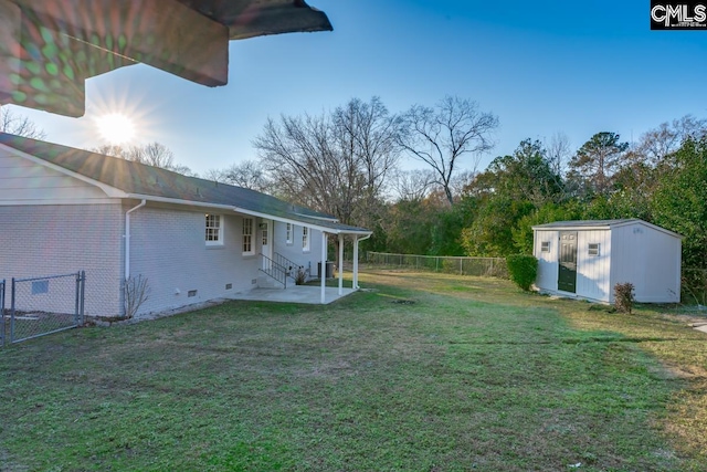 view of yard with a fenced backyard, entry steps, an outdoor structure, a storage unit, and a patio area