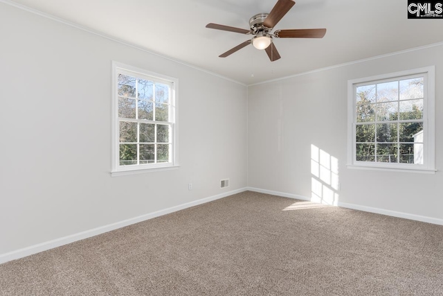 empty room with visible vents, crown molding, baseboards, carpet, and a ceiling fan