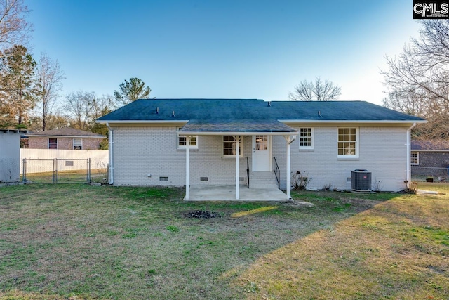 back of property featuring crawl space, central air condition unit, a lawn, and fence