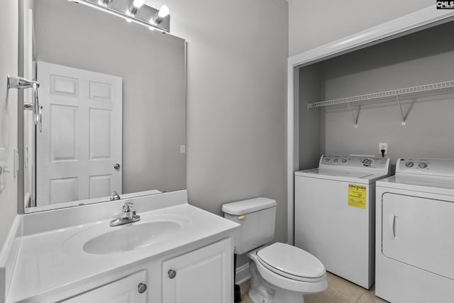 bathroom featuring tile patterned flooring, washing machine and dryer, toilet, and vanity