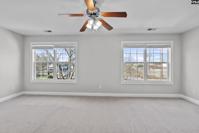 unfurnished room featuring baseboards, plenty of natural light, carpet, and visible vents