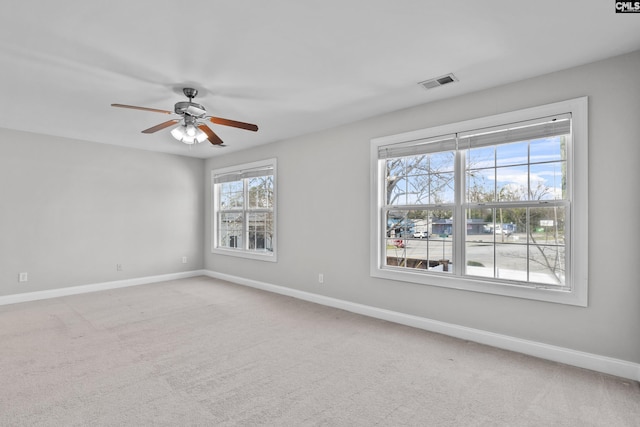 carpeted empty room featuring visible vents, baseboards, and a ceiling fan