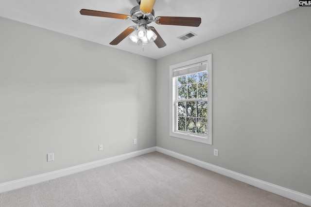 spare room with visible vents, light carpet, baseboards, and ceiling fan