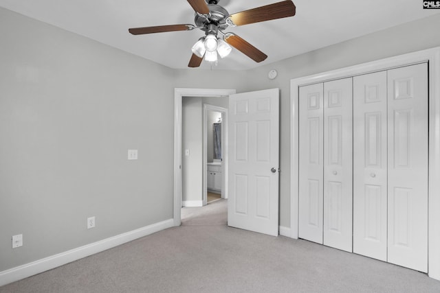 unfurnished bedroom with a closet, baseboards, light colored carpet, and ceiling fan