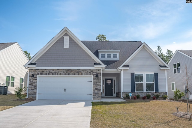 craftsman-style house with stone siding, an attached garage, concrete driveway, and a front yard