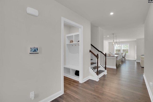 hall with built in features, baseboards, dark wood finished floors, recessed lighting, and an upstairs landing