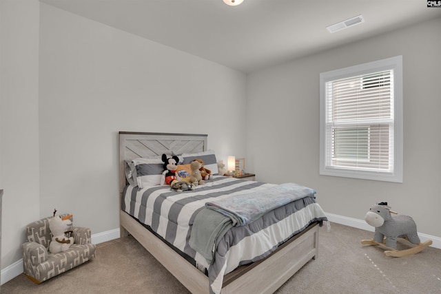 carpeted bedroom featuring baseboards and visible vents