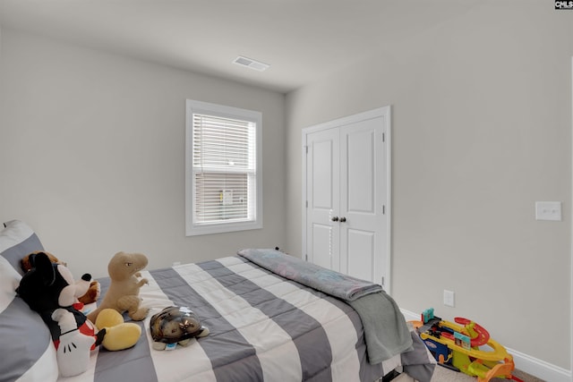 bedroom with visible vents, baseboards, and a closet