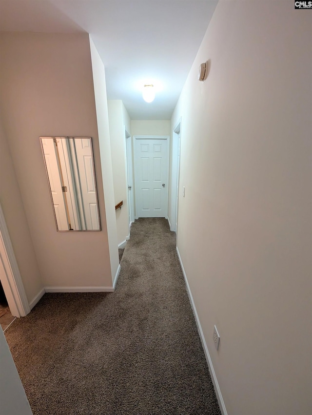 corridor with an upstairs landing, baseboards, and carpet floors