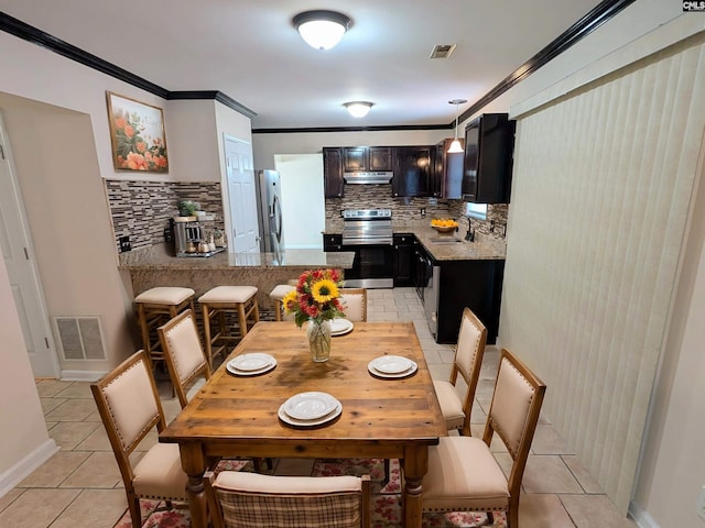 dining room featuring light tile patterned floors, visible vents, baseboards, and ornamental molding