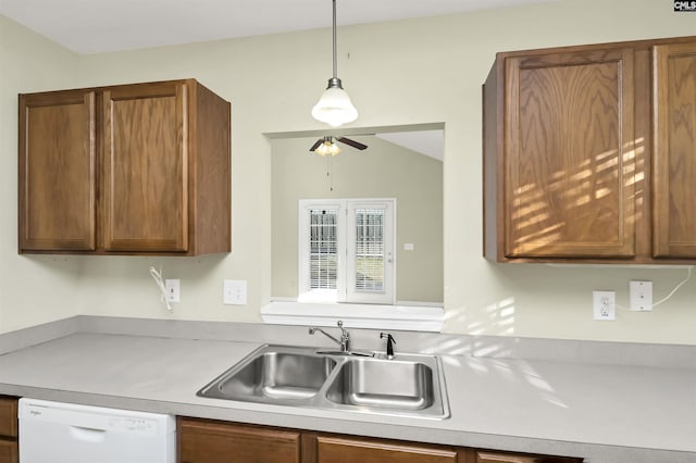 kitchen featuring a ceiling fan, a sink, white dishwasher, light countertops, and hanging light fixtures