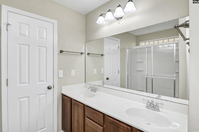 full bath with a shower stall, double vanity, and a sink