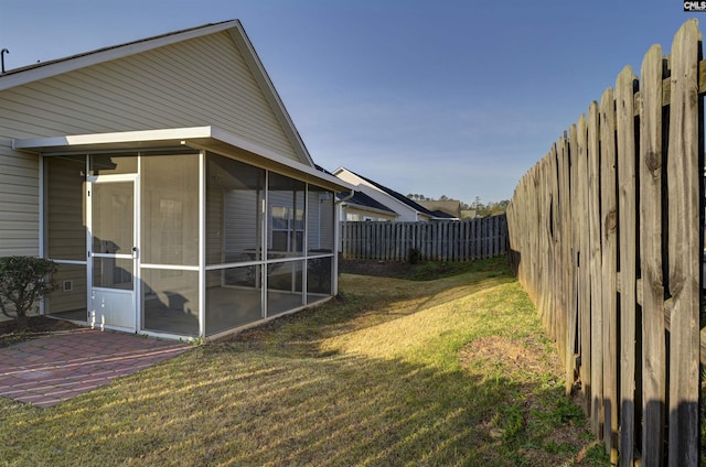 view of yard featuring a fenced backyard and a sunroom