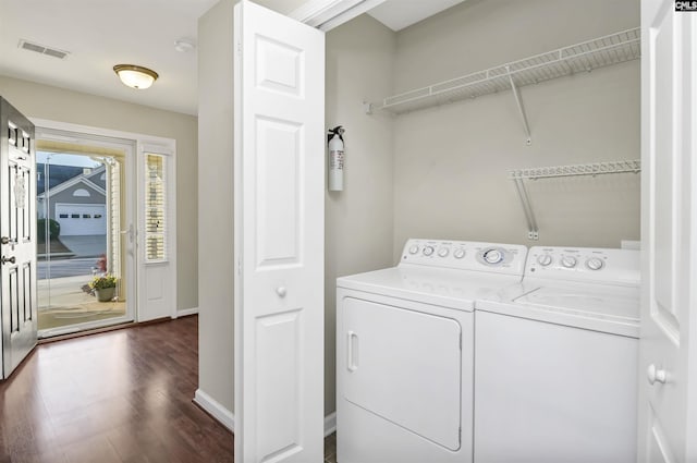 washroom featuring visible vents, baseboards, laundry area, separate washer and dryer, and dark wood-style flooring