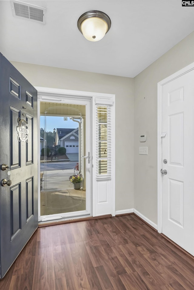 foyer entrance featuring visible vents, baseboards, and wood finished floors