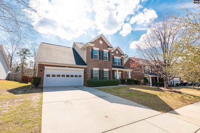 traditional home with brick siding, a front lawn, fence, concrete driveway, and a garage