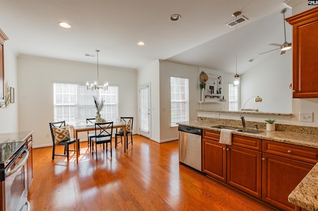 kitchen with visible vents, light wood-type flooring, pendant lighting, a sink, and appliances with stainless steel finishes