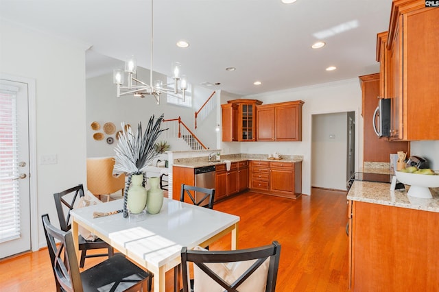 dining space with a chandelier, recessed lighting, light wood-style flooring, and crown molding