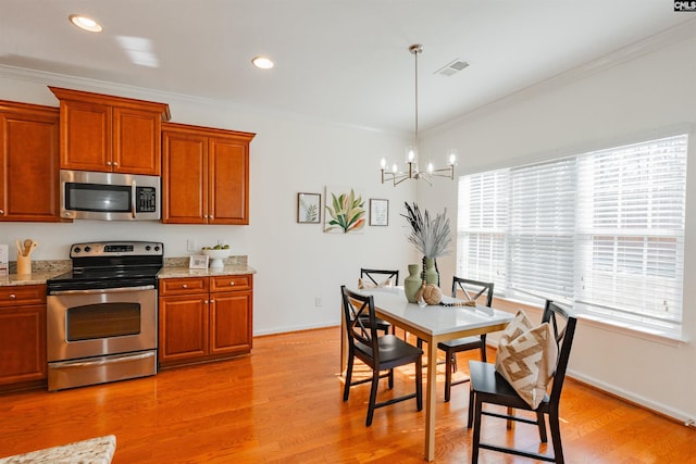 kitchen featuring visible vents, an inviting chandelier, appliances with stainless steel finishes, crown molding, and light wood finished floors