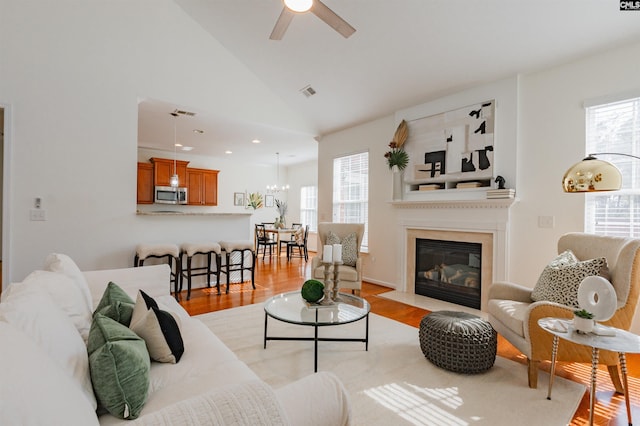 living room featuring a high end fireplace, visible vents, ceiling fan, light wood-style flooring, and recessed lighting