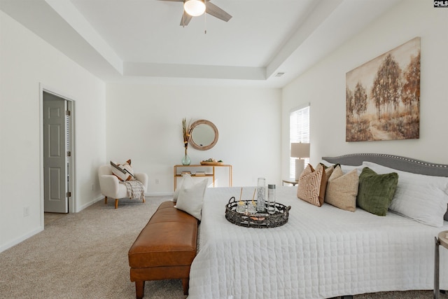 bedroom with a tray ceiling, visible vents, baseboards, and carpet floors