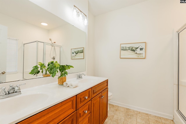 full bathroom featuring a sink, toilet, a stall shower, and double vanity