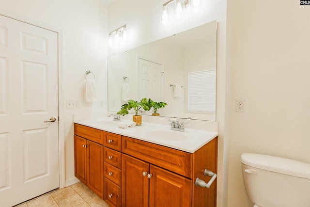 full bathroom featuring a sink, toilet, double vanity, and tile patterned floors