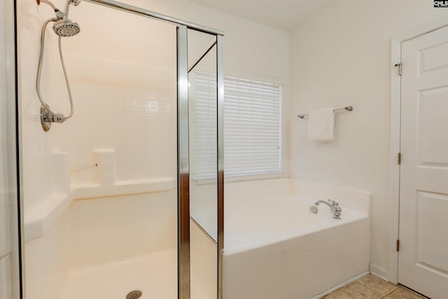 bathroom featuring a bath, tile patterned flooring, and a shower stall