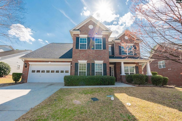 traditional-style home featuring brick siding, concrete driveway, a front yard, and a garage