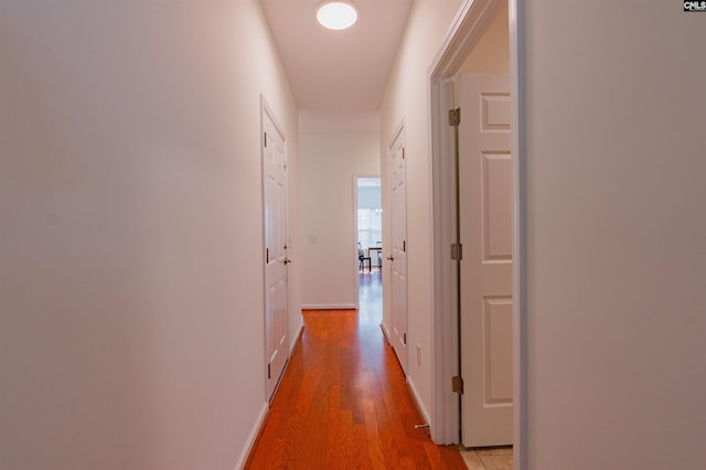 hall featuring baseboards and light wood-style floors