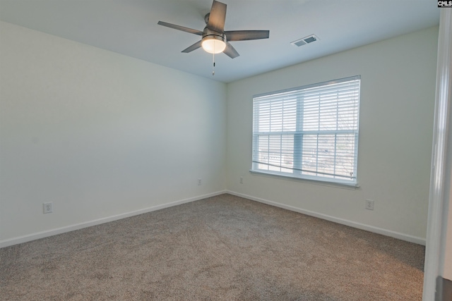 carpeted empty room featuring visible vents, baseboards, and a ceiling fan