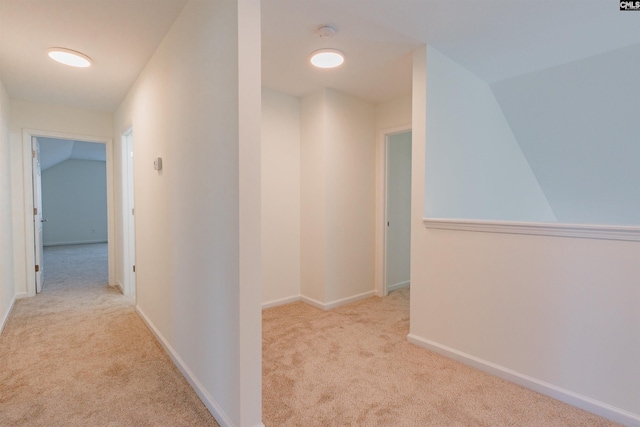 hall featuring vaulted ceiling, baseboards, and carpet floors