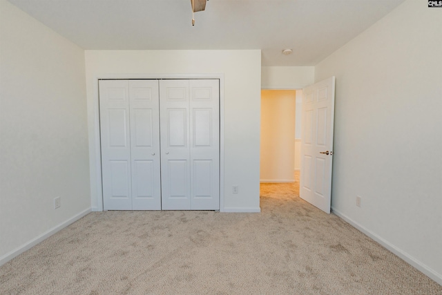 unfurnished bedroom featuring baseboards, carpet floors, a closet, and a ceiling fan