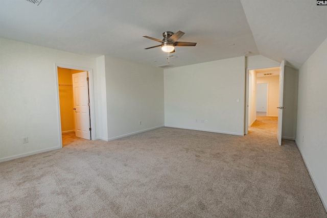 interior space with a spacious closet, ceiling fan, baseboards, and carpet