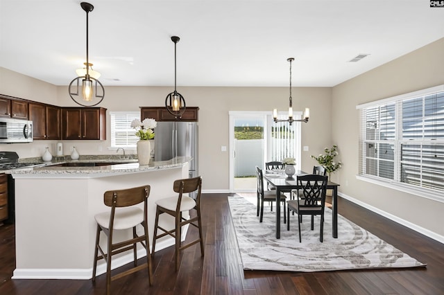 kitchen with dark brown cabinetry, visible vents, a wealth of natural light, and stainless steel appliances