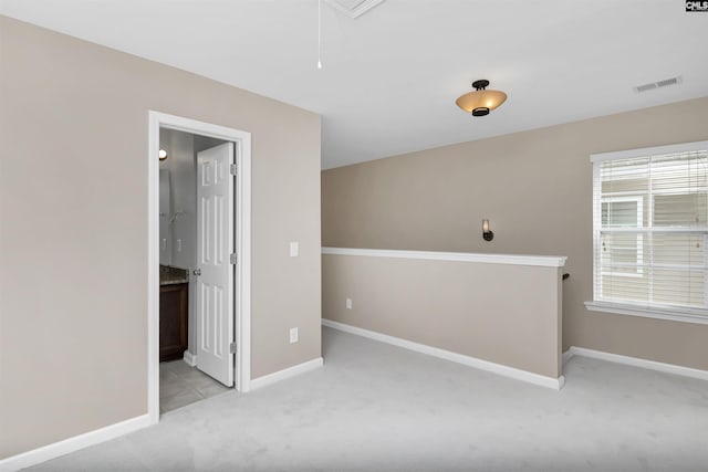 empty room with visible vents, baseboards, carpet, and attic access