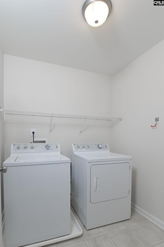 clothes washing area with laundry area, baseboards, and independent washer and dryer