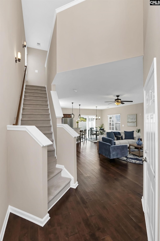 staircase with baseboards, wood finished floors, and a ceiling fan